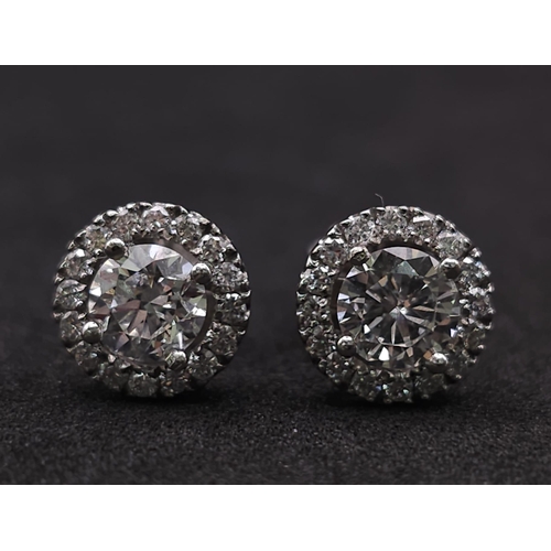 232 - PAIR OF 18K WHITE GOLD DIAMOND HALO STUD EARRINGS, WITH 1.20CT MAIN ROUND BRILIANT CUT STONES, AND F... 