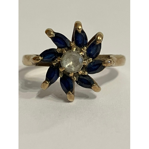 378 - 9 carat GOLD RING Set with BLUE and WHITE TOPAZ in Attractive floral star form. 2.9 grams. Size M.