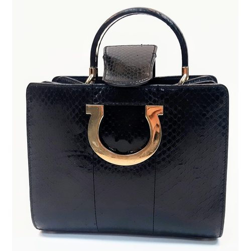 680 - A Salvatore Feregamo Black Snake Skin Handbag.
Single top handle with gold tone hardware and a magne... 