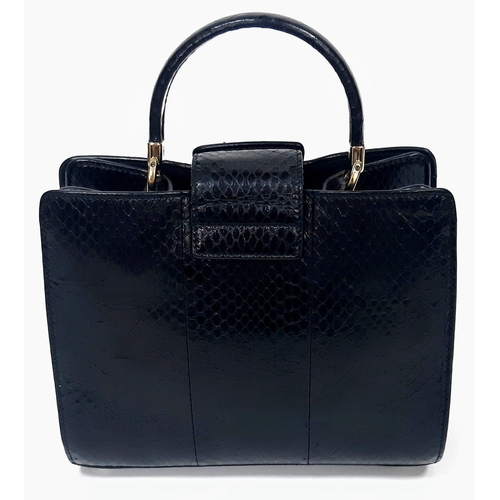 680 - A Salvatore Feregamo Black Snake Skin Handbag.
Single top handle with gold tone hardware and a magne... 