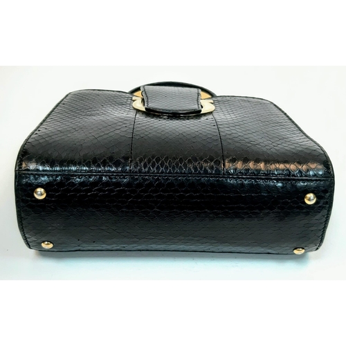 680 - A Salvatore Feregamo Black Snake Skin Handbag.
Single top handle with gold tone hardware and a magne... 