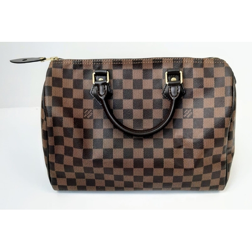 645 - The Louis Vuitton Speedy 35 in Damier Ebene canvas is a timeless and elegant handbag, measuring 31cm... 