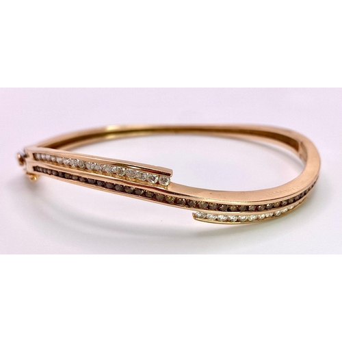 959 - A 14K Rose Gold, White and Cognac Brown Diamond Wave Bangle. Over 60 round cut diamonds ride on a wa... 