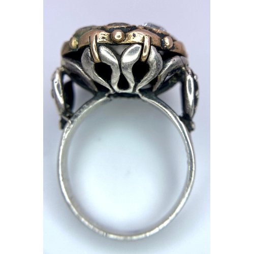 1417 - A 925 Silver Ring, with a fancy circular design adorned with white stones and interlaced with gold t... 