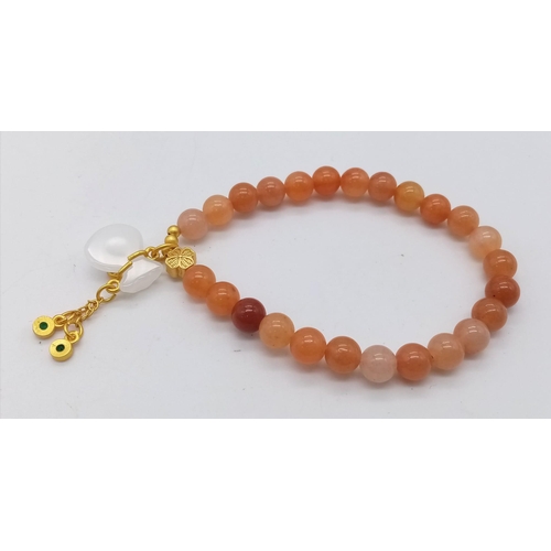 1692 - Peach Jade Stretch Bracelet with gold tone Chinese accent.
Measuring 6cm in diameter.