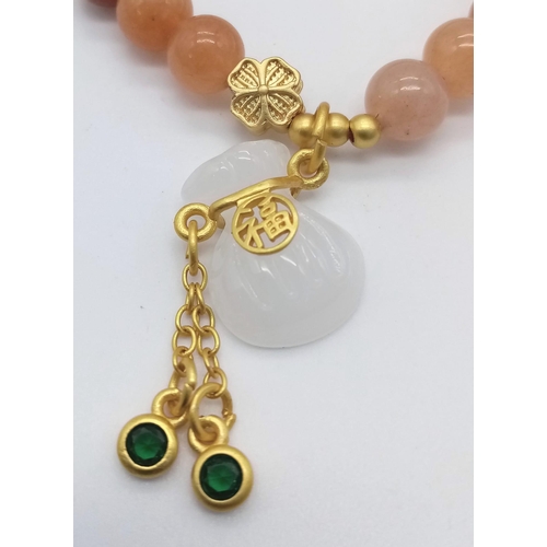 1692 - Peach Jade Stretch Bracelet with gold tone Chinese accent.
Measuring 6cm in diameter.