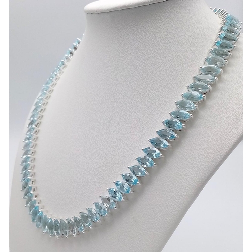 1344 - A icy Marquise Cut Blue Topaz, Tennis Necklace set in 925 Silver. Weighing 68.65g in total, this gor... 