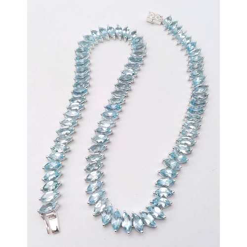 1344 - A icy Marquise Cut Blue Topaz, Tennis Necklace set in 925 Silver. Weighing 68.65g in total, this gor... 