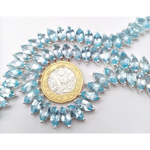 1344 - A icy Marquise Cut Blue Topaz, Tennis Necklace set in 925 Silver. Weighing 68.65g in total, this gor... 