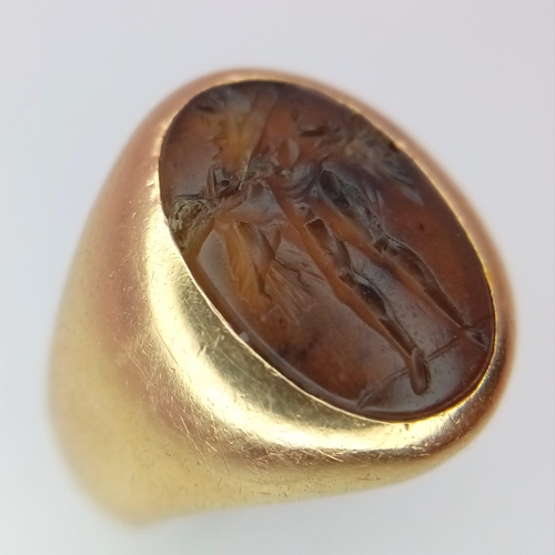 1150 - A Vintage 18K Yellow Gold Carnelian Signet Ring. A carved central stone of what appears to be an ima... 