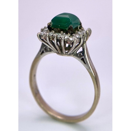 1613 - A Vintage 1975 (hallmarked) 18K White Gold, Diamond and Emerald Ring. A central square step-cut emer... 