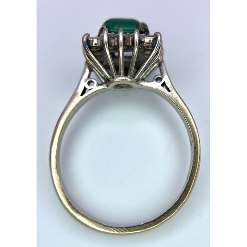 1613 - A Vintage 1975 (hallmarked) 18K White Gold, Diamond and Emerald Ring. A central square step-cut emer... 