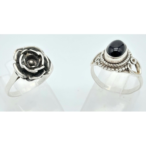 321 - A collection of Sterling Silver Rings.
One Flower Design, one Black Stone set.
Size: M (both)
Total ... 