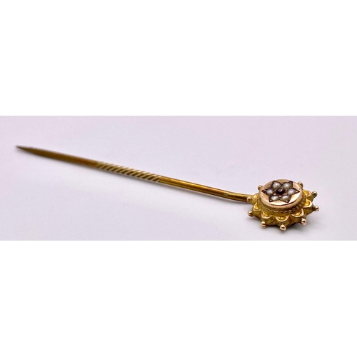 367 - An Antique Mid-Karat Gold, Seed Pearl and Ruby Stick-Pin. 5.5cm. 0.91g total weight.