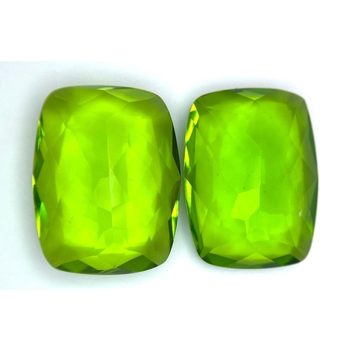 47 - A beautiful pair of large (16 carats each), emerald cut, PERIDOTS, with excellent colour uniformity ... 