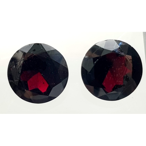 1114 - A Pair of 67.32ct Round Brilliant Shaped Dark Red Garnets. 20mm. AIG Milan Certified.