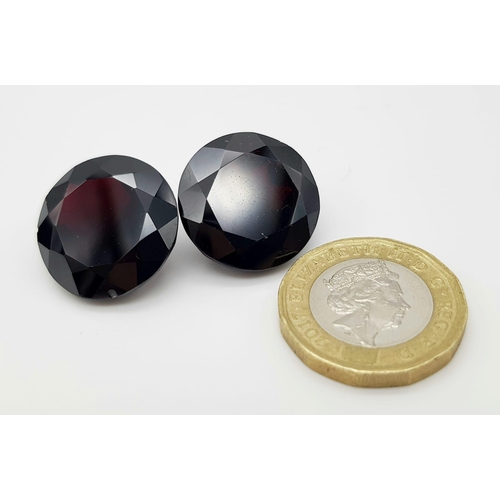 1114 - A Pair of 67.32ct Round Brilliant Shaped Dark Red Garnets. 20mm. AIG Milan Certified.