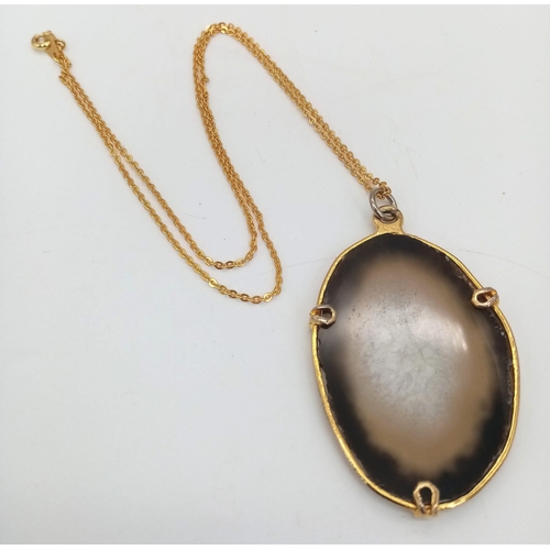 700 - A Sliced Agate Pendant on a Gilded Necklace. 5cm pendant. 42cm necklace.