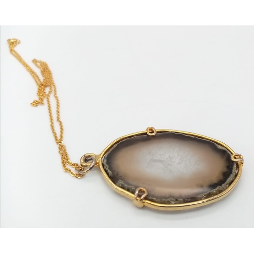 700 - A Sliced Agate Pendant on a Gilded Necklace. 5cm pendant. 42cm necklace.