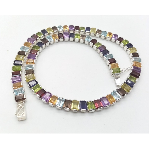 16 - A Kaleidoscopic Gemstone Tennis Necklace - Garnet, Amethyst, Blue Topaz and Smoky Quartz. Set in 925... 