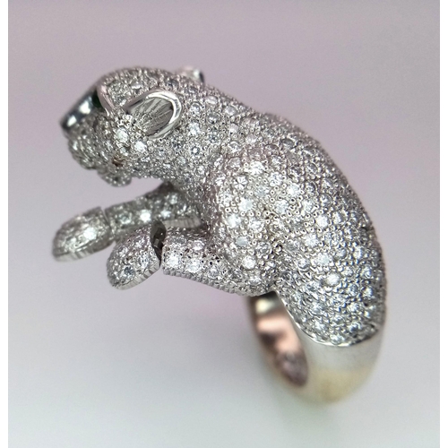 67 - An 18K Gold and Diamond Panther Ring. An encrusted, pave set pouncing Panther with Emerald eyes take... 