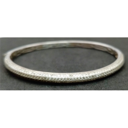 202 - A vintage 925 silver stone set click-on bangle. Total weight 12.15G. Widest inner length 7cm. Please... 