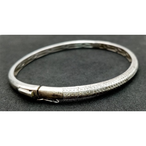 202 - A vintage 925 silver stone set click-on bangle. Total weight 12.15G. Widest inner length 7cm. Please... 