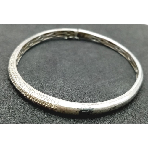 202 - A vintage 925 silver stone set click-on bangle. Total weight 12.15G. Widest inner length 7cm. Please... 