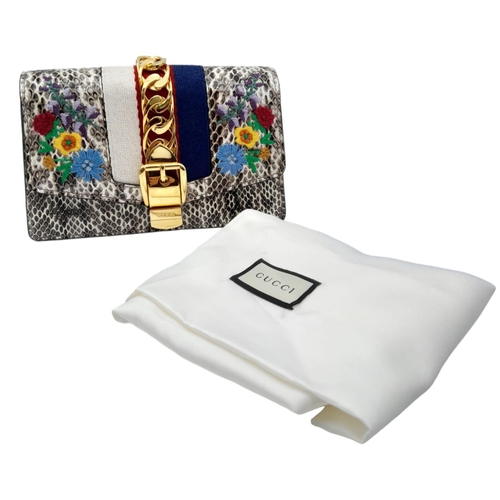 381 - Gucci Snakeskin Leather, Floral Embodied Bag.
This versatile bag can be carried as a clutch or a sho... 