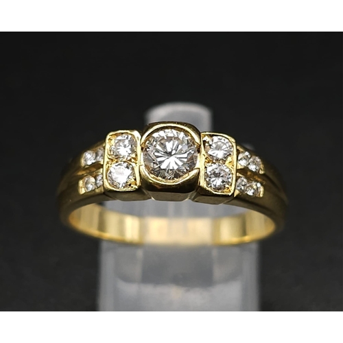 618 - An 18K Yellow Gold and Diamond Ring. A High grade central bright round cut diamond with 12 further d... 