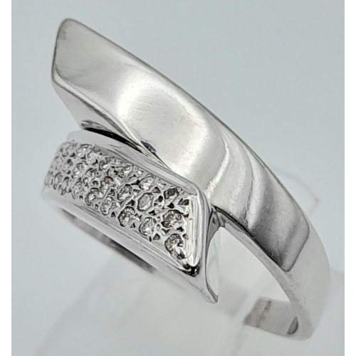 633 - An 18K White Gold and Diamond Crossover Ring. Size L. 5.36g total weight.