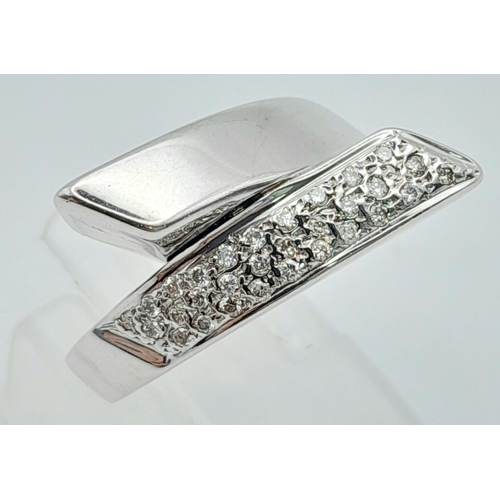 633 - An 18K White Gold and Diamond Crossover Ring. Size L. 5.36g total weight.