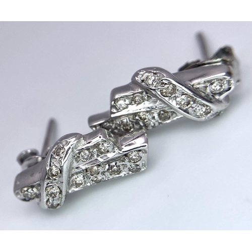 605 - A Pair of 18K Gold and Diamond Earrings. Diamond bow decoration. 3.58g total weight.