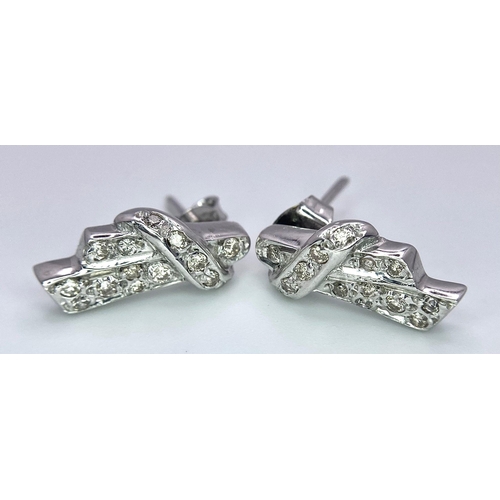 605 - A Pair of 18K Gold and Diamond Earrings. Diamond bow decoration. 3.58g total weight.