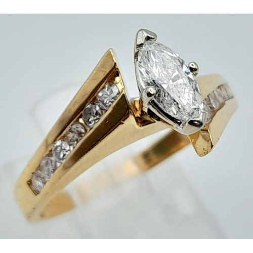 598 - A 14K Yellow Gold Marquise Cut Diamond Crossover Ring. Central marquise cut diamond with six round c... 