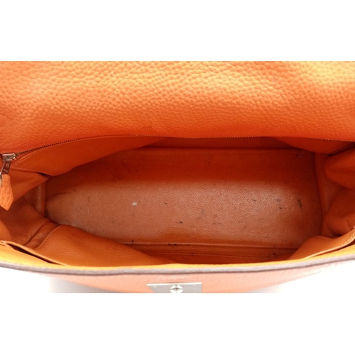 176 - A Hermes Kelly Orange Leather Bag. Textured burnt orange leather exterior. Open and zipped interior ... 