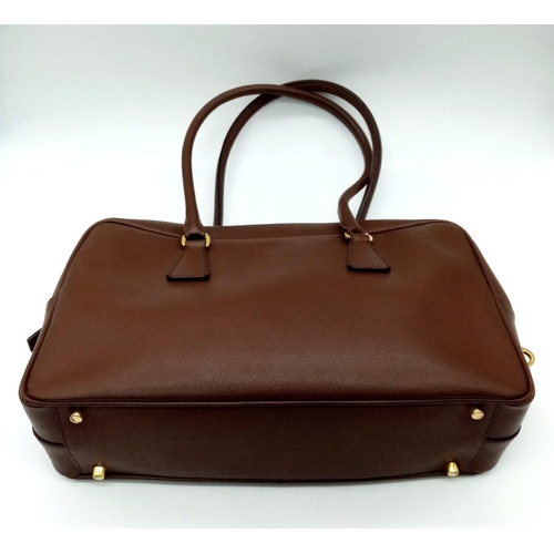 227 - A Prada Brown Saffiano Leather Handbag. Quality textured brown leather exterior. Gold-tone hardware.... 