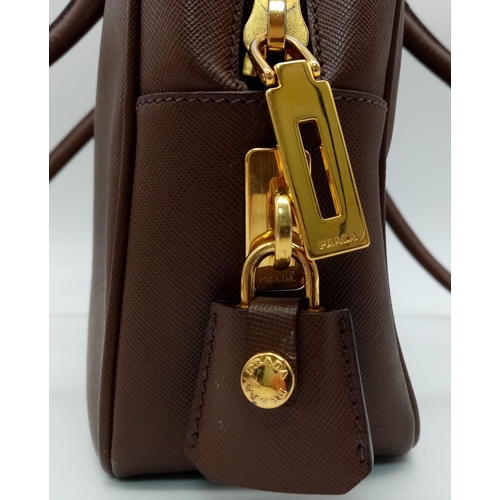 227 - A Prada Brown Saffiano Leather Handbag. Quality textured brown leather exterior. Gold-tone hardware.... 