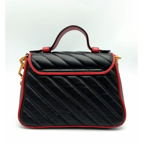 249 - A Gucci Marmont Torchon Mini Handbag. Two-tone padded leather exterior with a large GG gilded clasp.... 