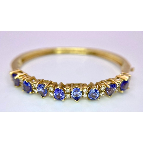 383 - An Alluring 14K Yellow Gold, Amethyst and Diamond Bangle. 
High-grade, clean pear-cut amethysts sepa... 