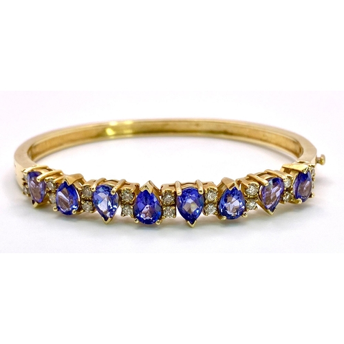 383 - An Alluring 14K Yellow Gold, Amethyst and Diamond Bangle. 
High-grade, clean pear-cut amethysts sepa... 