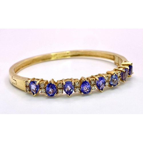 383 - An Alluring 14K Yellow Gold, Amethyst and Diamond Bangle. 
High-grade, clean pear-cut amethysts sepa... 