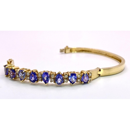 383 - An Alluring 14K Yellow Gold, Amethyst and Diamond Bangle. 
High-grade, clean pear-cut amethysts sepa... 