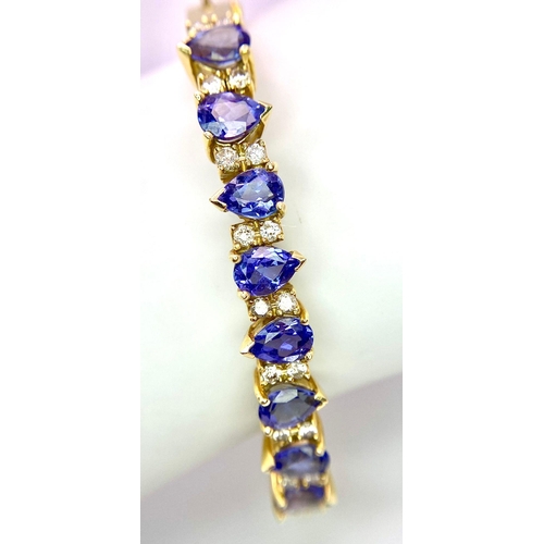 383 - An Alluring 14K Yellow Gold, Amethyst and Diamond Bangle. 
High-grade, clean pear-cut amethysts sepa... 