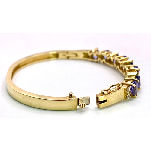 383 - An Alluring 14K Yellow Gold, Amethyst and Diamond Bangle. 
High-grade, clean pear-cut amethysts sepa... 