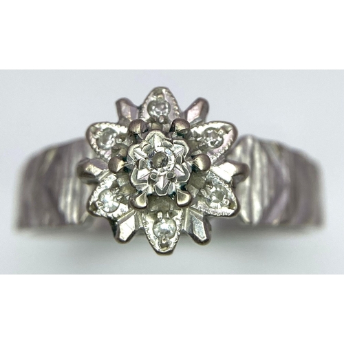 205 - A Vintage 18K White Gold Diamond Floral Ring. Ridged effect on shoulders. Size L/M. 3.36g total weig... 