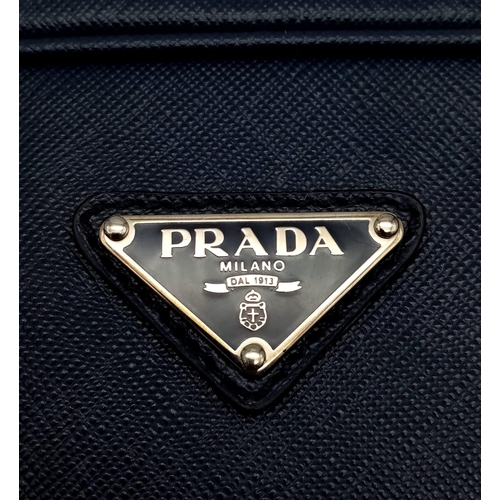 270 - A Prada Saffiano Briefcase. Navy blue textured leather exterior. Prada logo badge. Name tag. Quality... 