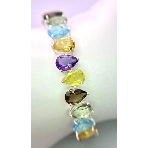 634B - A Kaleidoscopic Pear Shaped Tennis Bracelet. Amethyst, Blue Topaz, Garnet and Peridot! Set in 925 Si... 