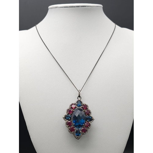 734B - This Blue Topaz, Ruby & Diamond, Sterling Silver Pendant Necklace is a jaw-dropper. 
With 30cts of B... 