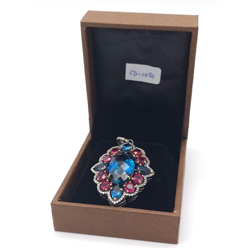 734B - This Blue Topaz, Ruby & Diamond, Sterling Silver Pendant Necklace is a jaw-dropper. 
With 30cts of B... 